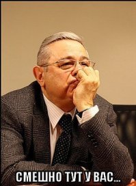 Девушка смешно руководит парнем, чтобы тот правильно её сфотографировал возле цветущей сакуры