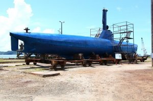 Это не подводная лодка,что за лодка которая при опасности не уходит на глубину. 30-метровая подводная лодка, задержанная в глубине джунглей в 2011 году, на сегодняшний день может считаться самым совершенным творением колумбийских криминальных конструкторов. В случае опасности она может погружаться на глубину до 9 метров с выключенным двигателем, становясь невидимой как с воды, так и с воздуха. На перископной глубине она может без дозаправки пройти весь путь из Колумбии в Мексику. Известно, что машина, способная взять на борт 8 тонн кокаина, совершила четыре успешных рейса.