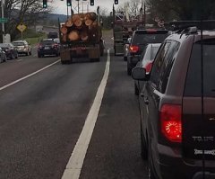 Наоборот - брёвна посыпятся вбок, так что самое безопасное место, за лесовозом. С учётом, конечно, что из него не сыпется всякий лесной мусор.