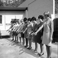 5-я с дальнего конца, с явным отвращением смотрит на свою чернокожую соседку ...