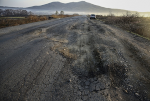 Это фотография дороги связывающую два крупнейших порта России, Владивосток и Находка. Подобные ямы можно без ущерба для авто, только объехать. Даже если их проезжать на очень маленькой скорости, есть риски повредить автомобиль. 
Так, что не надо умничать. Просто представьте, что вы едете по данному участку со скоростью 40 км/ч и увидев яму начинаете тормозить и пытаться ее объехать, как вдруг в зеркало заднего вида, появляется какой нибудь дол..б пытающийся вас обогнать и как итог вы влетаете в эту яму! А что касается тормозов...взади вас как бы тоже машины едут и резкое торможение, это риск получить в жопу.