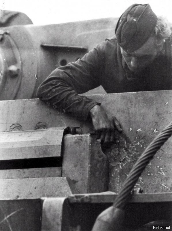 Мехвод тяжёлого танка Pz.Kpfw VI Tiger осматривает след от попадания советского снаряда в 102-мм бронелист своей машины.