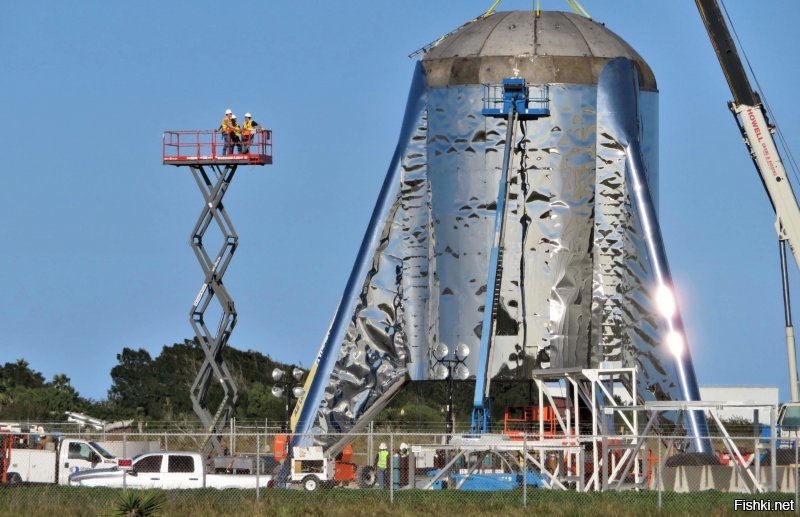 По видео сложно оценить реальный размер бочки диаметром 9м, фото с людьми рядом лучше передает ее габариты. По оценкам полный вес порядка 100 тонн, зависит от количества залитого топлива. Интересно, что корпус прыгуна построила сторонняя фирма специализирующаяся на постройке водонапорных башен.:) Получилось довольно быстро и недорого, главное работники SpaceX не отвлекались от постройки более продвинутых прототипов. Летающий стенд выполнил свою задачу - проверка в полевых условиях работы нового метанового двигателя и больше взлетать не будет.
Видео прыжка с другого ракурса, в реальном времени и замедленное.