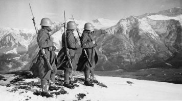 4 июня 1940 года Швейцария сбила два немецких самолёта за нарушение своей воздушной границы. Люфтваффе сказало "блядь", и попыталось отомстить хитроумно выманило 12 швейцарских истребителей на территорию Франции, где в данный момент велось наступление вермахта: там их атаковали 28 "мессершмиттов". Однако швейцарцы доказали, что умеют не только сыр на часах крутить они хоть и потеряли один самолёт, но подбили три вражеских. Третий рейх выматерился и нервно почесал в своём нацистском затылке. На следующий день происходит массированный налёт бомбардировщиков на Швейцарию с нулевым результатом, ибо огонь ПВО таков, что немцы опять потеряли 3 самолёта. Фюрер натурально расстраивается, и делает заявление как это ху..во, что немецкие арийские самолёты уничтожаются немецкими же самолётами, купленными за рейхсмарки у Германии (ибо на вооружении Швейцарии стоят аналогичные "мессершмитты"). Швейцария молча смотрит на часы, и мрачно ест сыр, как в последний раз. 16 июня 1940 года в Швейцарию забрасываются 10 немецких диверсантов с целью в качестве мести подорвать аэродром, и всех в тот же день арестовывают. Фюрер говорит фразу "да [мат] твою мать", и застывает в испуге, ибо понимает, что сказал её по-русски. Швейцария делает вид, что вконец поглощена п..здец каким вкусным сыром национального производства. Но понимает, что в общем-то дело плохо. 26 июня 1940 года командование рейха принимает план "Танненбаум" ("Елочка") по оккупации Швейцарии в три дня то есть, берется елочка, обертывается сыром, и засовывается Швейцарии в задницу. Такой план швейцарцам очень не понравился. Они приступили к быстрому строительству оборонительных сооружений по плану "Национальный редут". Основная часть этого плана была сделать оккупацию Швейцарии крайне неудобной и дорогостоящей. С этой целью в горах были построены доты и фортификации, заминированы дороги и туннели, и изъят из продажи дорогостоящий сыр в местах возможного прохождения частей вермахта. Офицерам было отдано распоряжение оборонять свои участки, невзирая на любые приказы вышестоящего начальства о прекращении сопротивления. Рейх вновь почесал свои нацистские затылки. Хотя Швейцария явно вы..бывалась, воевать и верно становилось накладно. Кроме того, были нужны пути в Италию (иначе их разрушат), и сохранение как нейтральной валюты швейцарского франка. По соглашению в августе 1940-го Швейцария обязывалась предоставить рейху бесплатный транзит грузов, и дать кредит в 150 миллионов франков. Поставки сыра и часов были оформлены тайным отдельным соглашением. Германия отвела войска от швейцарских границ, и угроза войны миновала. В 1944 году Швейцария запретила транзит нацистских грузов. Рейх обещал [мат], но ему было уже не до Швейцарии, ему самому ёлочку в известное место без сыра засунули. 28 апреля 1944-го на аэродроме в Цюрихе сел повреждённый немецкий истребитель с секретным оборудованием командир и объяснил, что он тут просто за сыром, вот сейчас купит килограммчик и обратно полетит. Швейцарцы не поверили. Дабы самолёт не попал в руки союзников, бригаденфюрер СС Шелленберг предложил уничтожить технику, а взамен Германия поставит Швейцарии 12 истребителей за символическую цену. Швейцария согласилась, и сожгла самолёт [мат]. А немцы взяли, и кинули их, как напёрсточники на рынке в девяностых годах продали перекрашенные старые самолёты с изношенными двигателями. А потом взяли да и проиграли войну вот уж на..бали, так на..бали. Но Швейцария подала в суд, и в 1951 отсудила у фирм "Мессершмитт" и "Даймлер" кучу денег. Те были так разочарованы, что пи..дец просто. Экая ведь сырная коммерческая нация. На снимке швейцарский патруль в Альпах показывает представителям вермахта, что накуй это вон туда. …

Источник:  © Fishki.net