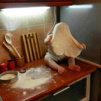 Родители, видимо, пытались "смешную" фотку сделать. 
Видно же, что ребёнок пытается СТЯНУТЬ с себя АБСОЛЮТНО РОВНО РАСКАЧАННОЕ тесто. Ни при каких условиях малыш так аккуратно бы его себе на голову не взгромоздил.

Родители - гении