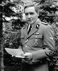 Вот правильная форма Штирлица и правильное ношение знаков отличия к весне 45-го. Видимо это фото с кинопроб, но почему отказались от истинного соответствия формы в фильме, непонятно. Наверно черная форма СС выглядела более зловещей для зрителя и контрастно смотрелась в черно-белом кино.