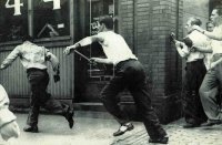 Детройт: негритянский бунт 1943 года
В 2013 году американский город Детройт прославился как первый город в США, официально признанный банкротом.
Это настоящая столица "ржавого пояса" Америки - городов-призраков с брошенными заводами.
А вот 70 лет назад Детройт называли самым прогрессивным городом - именно здесь вспыхнула первая "черная" революция, когда афроамериканцы восстали против белых.
По законам военного времени революция, которую мир предпочел не заметить, была раздавлена танками.



Все началось с того, что во время Второй Мировой войны один из ключевых центров мировой автомобильной промышленности, город Детройт, перешёл на выпуск военной продукции. Промышленные предприятия выпускали военные изделия столь успешно, что умудрились выпустить 1/3 всей военной продукции США, а за городом закрепилось неофициальное название «арсенал демократии».
Однако не всё было хорошо и безоблачно. Мобилизация рабочих с заводов на службу и одновременно с этим рост производства привели к проблеме нехватки рабочих рук. Проблема решалась за счёт привлечения свободных рук из Южных штатов, в том – темнокожих. Проблема с нехваткой рабочих рук на производстве была решена, однако вылезла другая проблема – демографическая, город был не подготовлен к приёму такого большого количества «специфических» рабочих рук.

«Специфической» рабочей силой темнокожие рабочие стали потому, что Детройт ещё с 1920-х годов стал одним из главных оплотов Ку-клукс-клана, а если присовокупить к этому действие закона о сегрегации, и жилищные условия, в которые попали темнокожие (200 000 человек жило на территории в 60 кварталов, в т.н. «Райском уголке») привели к росту социальной напряжённости, которые могли привести привести к взрыву.



Так за 1942 год произошел ряд крупных столкновений между белокожими и темнокожими, однако эти волнения удалось подавить местным властям без привлечения сил из федерального центра. Но в 1943 году произошли настолько массовые столкновения, что для их усмирения американскому правительству пришлось привлекать войска, предназначенные для отправки на Европейский театр военных действий. Бунт начался с банальной драки между белыми и чёрными подростками в парке развлечений Белл Айсл душным летним вечером 20 июня 1943 года. В таких драках за белых подростков заступались матросы с находившейся в городе. Так произошло и в этот день, однако история имела продолжение в виде ещё одной драки на сей раз между матросами и чернокожими жителями, на мосту у парка. Вскоре к матросам начали присоединятся местные белокожие жители, которых собралось у моста около 5 000.



К этому моменту в городе распространились слухи: в местах проживания темнокожих ходили слухи о том, что белые матросы скинули с моста чернокожую женщину с ребёнком, а в белой части города - чернокожий мужчина изнасиловал и убил белую женщину прямо на мосту. Подогретые этими слухами беспорядки набрали такую силу, что уже к полуночи 20 июня полиция перестала контролировать обстановку в городе.



Чернокожие жители крушили магазины, принадлежавшие белым, а также атаковать всех людей с белым цветом кожи, попадающимся им на глаза. Белые начали ломать и сжигать магазины, дома и автомобили, принадлежащие чернокожим. Толпа белых прошла по Райской Долине, сметая на своем пути машины, дома и магазины.



Беспорядки продолжались всю ночь, лишь к утру мэр Детройта Эдвард Дж. Джеффрис попросил помощи у федеральных властей.

Федеральные власти ввели в город 6 000 солдат которым удалось утихомирить город к полуночи 21 июня. В результате беспорядков в городе было убито 25 чернокожих (из них 17 – полицией) и 9 белых жителей, материальный ущерб составил порядка 2 000 000 долларов.