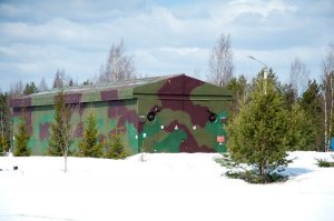 Ну как бы кроме пусковых в полку куча других машин.  Да и как боевое дежурство там несли? Где был командный пункт? Как осуществлялась охрана?
Обманули вас. Не было там Тополей. 
А вообще ПУ стоят в таких ангарах.