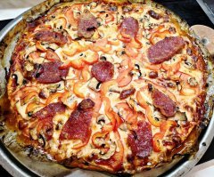 И так автор ,как и обещал, попробовал, и напишу тут свои ощущения и замечания, или даже критику ,понимай как хочешь.
Изначально взял ингредиентов на две пиццы, почему? Ну как минимум потому что уже на прочтении твоего рецепта понял, что к сожалению, идея отличная ,а вот исполнение будет провальным.  Так в принципе и вышло.
Ну обо всем по порядку. Первую делал точно по твоему рецепту, теперь по пунктам. 
1 «На мясорубке перемолоть куриное филе вместе с батоном. Добавить соль по вкусу, также можно добавить другие специи, но я предпочитаю делать основу нейтральной.

Батон вымоченный в этом рецепте, как минимум уже звучит очень странно. Батон вымоченный вводится в фарш, для того что бы придать ему дополнительно сочность. Для котлет – супер , а вот для основы пиццы .где сам бог велел наоборот ,максимально подсушить фарш ,что бы он не плыл, это уже ошибка.
Основа нейтральная…хм звучит еще более странно , если взять во внимание что все что ты добавляешь в пиццу то же на 99% нейтрально. Моцарелла – абсолютно нейтральный сыр. Шампиньоны- абсолютно нейтральный гриб с очень низкими вкусовыми и ароматными качествами. Помидоры- очень низкий вкус. Что же тогда будет давать вкус? 

2 Томатный соус смешать с 1 измельченным зубчиком чеснока.
Соус должен был взорвать. А у тебя томатный кетчуп с зубчиком чеснока. Я заплакал когда это увидел. 

Итог: Абсолютно нейтральный вкус, пицца под сыром потекла. Хотя я  и использовал форму перфорированную под пиццу ,что бы как можно быстрее ее прихватить, ни чего не вышло. Твой батон сыграл очень плохую шутку. Ты лихо разрезала свою пиццу, очень мягко скажу,
- ой ли?
Уверен что кадры где ты отдирала пиццу от бумаги остались за кулисами. А именно так и произойдет .как бы ты не смазывала, фарш100% пристанет ,и надо очень поковыряться что бы его как минимум просто снять. Пицца практически не имеет вкуса, да еда ,да красиво но не какого эффекта УХ даже и близком не пахнет.
Мои изменения ,очень советую тебе взять на вооружение для приготовления этого блюда. Они поверь мне выведут на совершенно новый уровень. 
1 Ни каких батонов, а вот панировочные сухари в сам фарш, очень и очень хорошо себя покажут в дальнейшем. Выпикание,  на подушке из панировочных сухарей. Даст неимоверную корочку и определенную устойчивость фаршу, однозначно плюс. И при этом, ни каких проблем с приставанием, прекрасно отделяется и нарезается.
2 Фарш делал вкусным, соль+перец+ орегано+ красная копченная паприка
3. Соус варил 50/50 помидоры в собственном соку/ томатная паста , соль+сахар, сливочное масло, тимьян розмарин ,чеснок, и соус из черного перца, вываривать до густоты
Вкус соуса и насыщенность – овер ,потому что это основа вкуса
Начинка, от себя добавил – болгарский перец и пару ломтиков салями
И вот во втором варианте ,этот рецепт уже заиграл совершенно другими красками