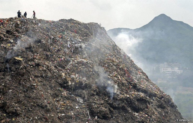 Рабочие свалки на вершине мусорной горы в Гуйян, юго-запад Китая