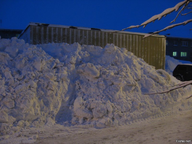 "Снег немножко"?! 
Эти фотографии я сделал 17 февраля днём, сразу после расчистки двора. С тех пор было ещё несколько снегопадов, снега стало ещё больше, горы вокруг машин и сугробы под окнами стали ещё выше (окон первых этажей с дороги уже не видно, а на этих фотках ещё видно).
В ночь с 16 на 17 февраля всего за 6 часов снежный буран так завалил и задул город, что утром многие жильцы домов не могли выйти из подъездов (фотка отдельным комментарием ниже). У меня двор задуло так, что напротив второго подъезда образовался снежный вал высотой сантиметров 65 и длиной в несколько метров, и расположился этот вал наискосок и поперёк дороги. Я утром вышел к машине и офигел: к самой машине слева не подойти, зарыта по стёкла, на дороге сантиметров 30 снега по всей длине двора и тот самый перемёт у второго подъезда. Перемёт пробивали вдвоём с другим водителем.