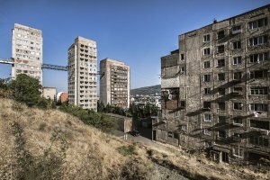"Работы Каландаришвили и Поцхишвили не ограничиваются лишь общественными зданиями. В середине 1970-х архитекторы проектируют комплекс жилых домов на крутом склоне по улице Нуцубидзе. Три типовых крупнопанельных корпуса расположены по возрастанию. Нижний, 16-этажный, выполняет функцию дома-распределителя, ещё два 9-этажных расположены выше. Объекты соединяет серпантинная дорога. В доме-распределителе запроектированы группы лифтов, а от него к вышестоящим корпусам ведут переходы, расположенные на разных уровнях."(c)