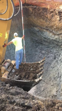 Автор, это нормальный процесс, нивелировка, тут даже грунта набрано в ковш что бы "реечнику" было удобно стоять, просто котлован не позволяет расширение стенок, либо монтаж лесницы для спуска