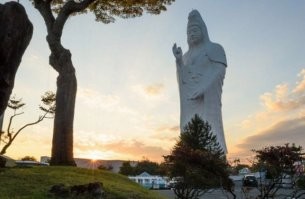"Статуя Сэндай Дайканнон в городе Сэндай высотой 100 метров была построена в 1991 году. Статуя изображает буддийскую богиню Каннон, несущую жемчужину желаний Нёиходзю в правой руке и небольшой сосуд с водой мудрости в левой руке, что классифицирует её как «Каннон, исполняющую желания».
Внутри статуи действует лифт для посетителей, на котором они могут подняться на вершину статуи (12-й этаж), где расположен храм, посвящённый богине и откуда открывается панорамный вид на Сэндай. Спуск производится по лестнице, расположенной также внутри статуи. На каждом из уровней имеются по восемь статуэток будд, размещённых в деревянных шкафах, всего 108, символизирующих человеческие страдания и заблуждения.
Вход в сооружение оформлен в виде пасти дракона. В зале первого этажа расположены 33 статуи богини, олицетворяющие человеческие желания и 12 статуй, соответствующих китайским знакам китайского календаря.
По легенде одним из воплощений богини Каннон является «зовущая кошка» Манэки-нэко, также в её честь названа японская компания Canon" -  Википедия.

В очередной раз копипастят эту фотку (. 
Можно было бы и описание "приложить"...