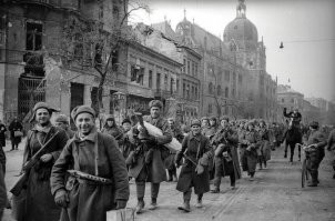 Мой дед брал Будапешт в феврале 1945-го, был награжден медалью за его взятие. Есть его фотографии военных лет. Поэтому взяли сомнения насчет этого фото с расхристанными "красноармейцами". Где погоны на шинелях и звездочки на шапках - в 1945-м году? Что это за форма одежды? Что за клоун в котелке среди бойцов? 
Этот снимок в поиске выдал, что его используют и в статьях об освобождении Вены, и Братиславы, и Кенигсберга, и кучи других городов. Что-то здесь не так...