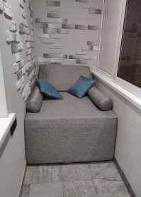 Мы с мужем тоже балкончик оборудовали. Промежуточных фоток к сожалению мало. Плитка декоративная, недорогая, покупали вроде в Оби, клеила сама по вечерам после работы на клеевой пистолет. Слева и сзади стена покрашена, сбоку наклеили остатки плитки от ванной, не очень практично, но все равно зашло.  Диванчик давно хотели на балкон, но подобрать ложе под наши размеры оказалось невозможно. Прошлым летом нашла контору, которая делает такие диваны под заказ, посмотрели фото работ, каркас...  И поняли, что сможем сделать такое сами! 
На рынок ходили как к себе домой: за саморезами, уголками, мебельным поролоном, тканью, еще раз за тканью, еще раз за уголками и два раза за ручкой дивана (первая благополучно похерилась в этом хаосе). 
 Я ни разу не швея, но клей и иглу с ниткой освоила.  Ненужный хлам в итоге лежим именно под диваном =) 
Немного кособокий, швы на валиках не идеальны, но для балкона самое оно). Теперь хочу столик откидной приделать, чтобы было куда ставить кофе по утрам.