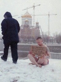 Оригинальный попрошайка - это Иван Охлобыстин. Помню,это была серия фотографий для какого-то в то время крутого журнала. Там он ещё в метро с этим плакатом...