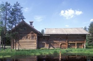 Дома-кошели характерны больше для Карелии, а идея взята у финов. В Архангельской области например, богатые крестьяне, а только они могли себе построить такой огромный дом, строили дома-"глаголи" 

На фото дом Пуховых, из музея Малые Корелы - по центру вход, справа и слева избы для различных поколений одной семьи. Блок хозпостроек примыкает сзади. Общий план, если смотреть сверху - буква Т, ну или двойная Г, отсюда и название.