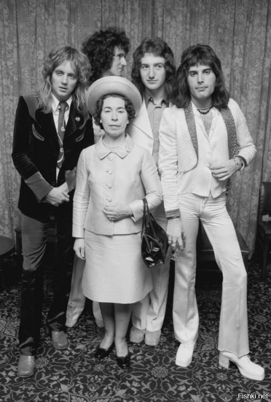Группа Queen позирует с актрисой похожей на королеву Elizabeth II, Джаннетт Чарльз, сентябрь 1974 года.