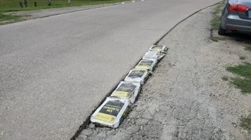 Побуду немножко Капитаном Очевидностью...

Мешки с цементом хранились во влажном месте. Отсырели. Окаменели. По сути, стали 25-килограммовыми бетонными блоками. Вполне прокатывают, как временное решение, дабы не ломать ноги в яме. 
Когда ещё дорожники исправят ситуацию?
Наш народ страшен своей импровизацией!
;)