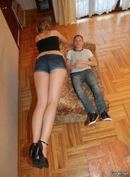 парень лежит на диване, а девушка на спинке дивана. Но все равно она высокая