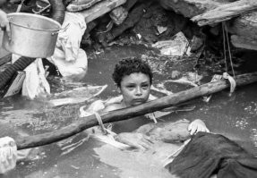 13 ноября 1985 г. неподалеку от колумбийского города Армеро произошло извержение вулкана Невадо-дель-Руис. Потоки лавы из кратера попали на горный ледник, из мгновенно растаявшего льда и вулканического пепла образовались селевые потоки, которые устремились каскадами вниз в долины рек. Двигаясь с большой скоростью (6 метров в секунду), первая волна захватила большую часть находившегося на пути города Армеро. 

В ночь катастрофы 13-детняя Омайра Санчес и её семья были разбужены шумом приближающегося грязевого потока. В мгновение ока Омайра оказалась под завалом в собственном доме. Долгое время девочку не могли обнаружить, поскольку сверху ее не было видно из-за бетонных плит перекрытия. Добравшись до Омайры, спасатели сумели отодвинуть плиты, когда они попытались освободить её, то выяснилось, что её ноги зажаты обломками.

Омайра Санчес   ребенок умиравший перед камерами Омайра Санчез, Длиннопост, Видео, Фото, История
Ребенка накормили, даже поставили капельницу. Омайра простояла в воде 60 часов и умерла, предположительно, от гангрены, или переохлаждения. Она пережила три ночи агонии. Девочка была очень напугана, часто молилась и плакала. На третью ночь у Омайры начались галлюцинации, она стала говорить, что боится опоздать в школу и просила людей, находившихся возле неё, пойти отдохнуть.

Спустя 60 часов Омайра умерла. 

За два часа до её смерти насос для откачки воды был доставлен, но он оказался неисправен. Только через четыре часа было доставлено 18 насосов.

Я помню как развивалась эта ситуация, все время думал - кругом беда - не достали за сутки-двое - значит не достанут. Надо спсать жизнь - орезать и спасать.....