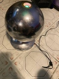 13 "Сверху из нее должны торчать тоненькие волокна, которые через верхние отверстие подсвечивает лампочка разными цветами вращаясь по кругу. Однако кто-то оторвал все волокна, уничтожив магию лампы".
Сверху вставлялся пучок из бесцветной лески, его просто вынули.
Вот современный аналог.