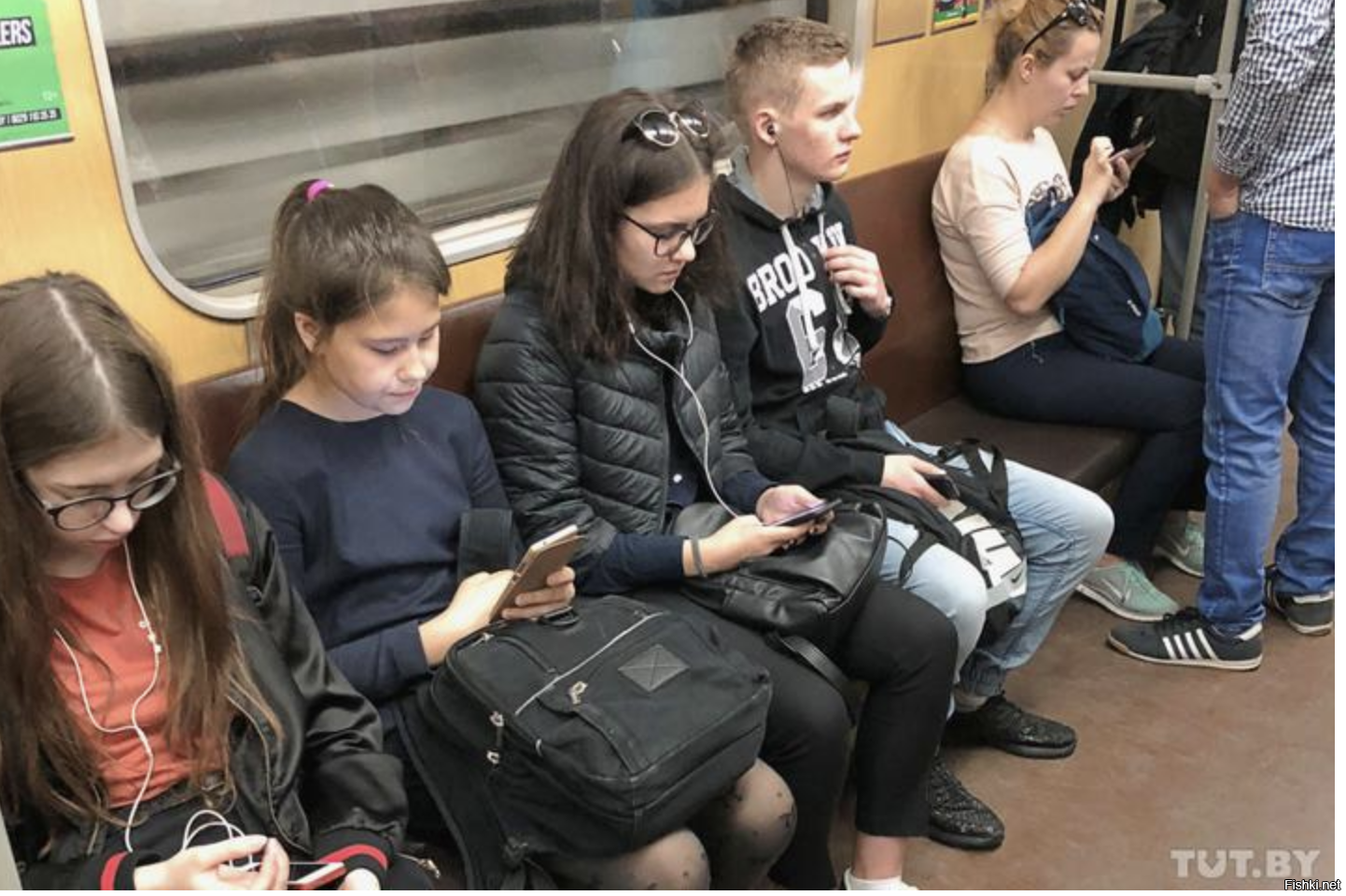 Подросток в московском метро. Люди со смартфонами в метро. Люди с гаджетами в транспорте. Люди в наушниках в метро. Человек в транспорте и смартфон.