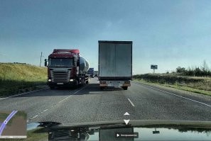 Куда вернулся? По каким правилам? 

Вот Вам панорама с началом подъёма, рег проезжает это место на 1:40. Ориентиров хоть отбавляй: крест, остановка, памятник, опора ЛЭП. Вверх идут две полосы, вниз спускается одна, отделённая сплошной. Инкассатор ехал в своей полосе никого не трогая. А дальше подъём забирает влево (второй снимок -- место аварии, ориентир - рекламный щит справа), что и стало причиной. Пьянь в поворот не вписалась и поехала прямо.