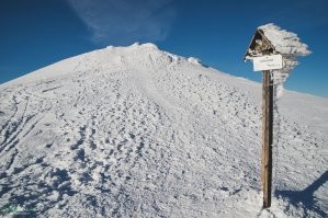 На границе Польши и Словакии есть подобное место. Бабья Гора называется.
Ветер дует всегда. Причем сильный.
Зимой забираться вообще ппц - то ещё приключение. Если с Польши идёшь - половина дороги по лесу, ещё норм, но вторая половина идёт по хребту, ветер постоянно в лицо. 
Со стороны Словакии - ещё хуже, весь путь по открытой горе, и ветер снова в лицо.
В общем как ни пойди всё время в рожу снег летит со страшной силой. 
А перед самой Бабьей горой есть вершина, называется Говняк :)