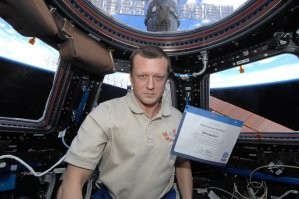 Американке и итальянцу вольно лыбиться, они пассажиры. А Кондратьев - командир, на нём вся ответственность. Тем более, что при подготовке корабль был повреждён и старт переносился. 
Да и вообще, он похоже, по жизни серьёзный мужик. Настоящий полковник.