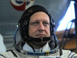 Американке и итальянцу вольно лыбиться, они пассажиры. А Кондратьев - командир, на нём вся ответственность. Тем более, что при подготовке корабль был повреждён и старт переносился. 
Да и вообще, он похоже, по жизни серьёзный мужик. Настоящий полковник.