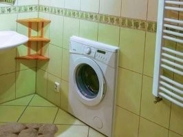 Это бред какой-то. Как бы хорошо ни был сбалансирован барабан и вся система в целом, даже при стирке, тем более при отжиме будут вибрации, которые должны как минимум пустить трещины по швам межплиточным, а в перспективе просто раскрошить стену