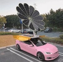 Ох уж эти "дизайнеры"... 

Вот нафига солнечные батареи в "параболоид" складывать? 
Что они там фокусировать собрались? 

И да, нафига оно там в таком размере? 

Подзарядить АКБ обычной машины с ДВС, много. 
Зарядить АКБ электромобиля, мало. 

Там, на вскидку, метра три квадратных. 
Ну пусть четыре. 
При идеальной инсоляции, с них ватт 650-700 снять можно. 
Но, на самом деле, меньше получится. 
Бессмысленная фигня для этого авто. 

---

И да, при сильном порыве ветра, эту машинку просто перевернёт. 
Ну или конструкция "ромашки" сломается.