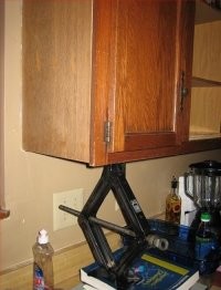 Тут, я думаю, все таки работа в самом разгаре и шкафчик таким образом зафиксирован на нужном уровне. Сейчас за шуруповертом сгоняет и закончит работу. Почему бы и нет, если один вешает?