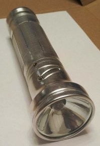 у "мталлических" фонариков была ещё одна "опция", про которую не упомянул автор - регулировка "светового потока" ( типа ближний/дальний свет у автомобиля ) - на фото видно диагональную прорезь и "направляющий" штырёк - при повороте отражатель смещался относительно лампочки вперёд/назад - и фонарик давал или широкий и относительно неяркий свет - или узкий и более яркий ...