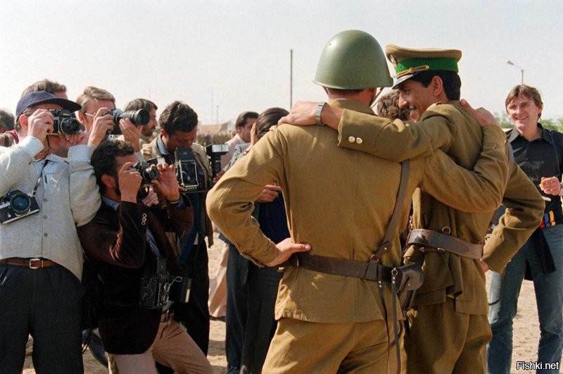 Подпись к фотографии:
Советский солдат и афганский офицер позируют прессе в центре Кабула, 20 октября 1986 года.

Каску носили не только солдаты, но все, кому целая голова была нужнее пробитой. Однако портупею давали только офицерам.
