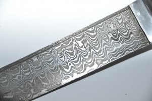 Дамаск это тигельная сталь сваренная из руды которую можно найти неподалеку от Дамаска, это руда с содержанием ванадия вплоть до 0.7%. Булат - та же история но из руды без легирующих добавок.

Да, металл насыщали углеродом почти до уровня чугуна, чтобы в рассплаве получался цементит (карбид железа - крайне твердый). Из-за этого при травлении действительно можно увидеть рисунок.

Однако он не слоистый, как в дешевых поделках доморощенных куйзнецов разных китайских национальностей, а скорее пегий. Слоистое говно делают Китайцы сковывая вместе БУ кастрюли, ручки от лопат и ломанную арматуру.
До этого такое же слоистое говно делали Японцы в своих катанах. 

В любом случае - не рекоммендую иметь ножи ни из булата ни из дамаска, это устаревшие, и уже довольно слабые стали, к тому же обладающие крайне низкой коррозийной устойчивостью. 

Даже хорошо отпущенный режик из современного напильника будет превосходить их по всем характеристикам.

Нормальная сталь для ножа - нержавейка, удобная. твердая (у меня ножи 58 HRC из мериканской А7 стали) и порезав сыр и не помыв вовремя нож вы не останетесь с куском железяки в ржавых рытвинах.