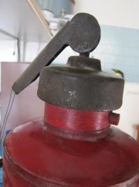 "перевернул огнетушитель, ударил клапаном об пол" - с  бойком были огнетушители ОХП.  Но к описываемому времени,  их уже лет 20  не существовало.
На первом этапе производства ОХП до 70-х годов,  кислотный заряд находился в стеклянной колбе и для приведения в действие устройства,  штоком огнетушителя необходимо было ударить о твердую поверхность – стену, поверхность земли, чтобы разбить ее.
В 90е уже были только ОХП -10. И бить его об пол бесполезно. Там надо повернуть ручку и перевернув огнетушитель, встряхнуть.
Товарищ аффтар не только в армии не служил, но и понятия не имеет  о огнетушителях.