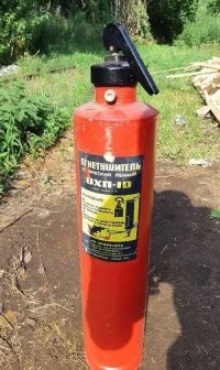 "перевернул огнетушитель, ударил клапаном об пол" - с  бойком были огнетушители ОХП.  Но к описываемому времени,  их уже лет 20  не существовало.
На первом этапе производства ОХП до 70-х годов,  кислотный заряд находился в стеклянной колбе и для приведения в действие устройства,  штоком огнетушителя необходимо было ударить о твердую поверхность – стену, поверхность земли, чтобы разбить ее.
В 90е уже были только ОХП -10. И бить его об пол бесполезно. Там надо повернуть ручку и перевернув огнетушитель, встряхнуть.
Товарищ аффтар не только в армии не служил, но и понятия не имеет  о огнетушителях.