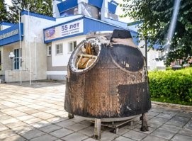 Один вон у меня (вернее на квартире у родителей в селе) даже с балкона видно , без всяких шуток, но это уже более современный, где то в начале 2000-х побывал в космосе, его я "не простукивал" , но на вид такой же, насчет материала, как и другой, 60-х, который внутри музея. Вот его я обследовал, со всех сторон. 
Там точно не асбест, что то типа пенобетона на звук постукивания . Но если сорвет защиту, то любой металл там вряд ли выдержит более чем несколько секунд. Иллюминатор там совсем маленький, с ладонь (ну, две ладони рядом по площади), так расположен, что он во-первых, со стороны парашюта, т.е. тыльной, а во-вторых, он хоть и закреплен в раме из металла, с уплотнителями наверняка, но снаружи заглублен и закрыт по бокам. 
Первый - космонавта 3, второй - который с балкона видно, на улице во дворе... даже и не знаю точно кто слетал, надо сходить табличку почитать