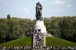 Солдата, которого увековечили в металле, звали старший сержант Николай Иванович Масалов. Он жил и здравствовал до 2001 года в поселке Тяжин Кемеровской области, в возрасте 79 лет оставил этот мир.

Во время штурма Берлина в одном из боевых эпизодов советский воин, рискуя своей жизнью, под плотным немецким огнем на руках вынес из-под обстрела трехлетнюю немецкую девочку. Скромный сержант не считал свой поступок подвигом, тем более, что таких случаев в ходе штурма Берлина было немало, но его подвиг стал широко известен благодаря многочисленным очевидцам. Этот поступок лег в основу идеи монумента Воину-освободителю в Трептов парке, в Берлине.