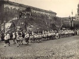 А.С. Абрамов. "У Кремлевской стены": 27 июля 1920 г. у Кремлевской стены открылась выставка трофеев Красной Армии. Вдоль братских могил и недавних свежих холмиков замерли французские броневики, английские танк и самолет, задрали дула орудия всех калибров и пулеметы всех систем, выстроились огнеметы, тягачи, прожекторы ...Тут был весь арсенал, брошенный буржуазией на уничтожение Страны Советов. В центре некрополя, перед Сенатской башней, вырос "Курган победы". На склонах этого искусственного холма, сооруженного саперами, валялись обрывки проволочных заграждений, разбитые колеса, ружья, барабан, торчали поломанные кусты. Только что тут "гремел бой", закончившийся разгромом врага. Как символ революционной бдительности на вершине холма белела трибуна, имевшая вид наблюдательного поста... Оттуда руководители страны и Коминтерна приветствовали в полдень марш 400-тысячной демонстрации красных воинов, рабочих, допризывников. Выставка трофеев открылась в честь II конгресса Коминтерна, но размещенная вдоль братских могил и свежих холмиков, явилась как бы боевым отчетом советского народа, его Красной Армии перед павшими героями.