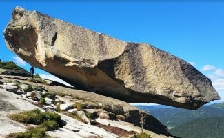 На Саянах есть такой камень. Он фигурирует в видео. Говорят раньше рукой можно было покачать. Еще существует байка, что годах в 70-80-х пытались его скинуть. Домкратили даже, нихрена не вышло. Меня больше интересует ни как он удерживается, а как он там появился. Притащить туда не реально. Туда дойти то сложно. Сверху упасть ни как не мог, т.к. выше и нет ни чего. Просто ветровая эрозия, ну в это как то сложно верится. На фото все не передать.