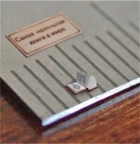 "Самая миниатюрная книга вмещается в ложку. Для ее чтения придется воспользоваться электронным микроскопом."
Ерунда какая-то написана. Если вмещается в ложу, то электронный микроском совсем не нужен.
Анатолий Коненко, Сибирский Левша, микроминиатюрист из Омска.
Чехов А. П. Хамелеон, 1996 г.; г. Омск; 29 страниц; 3 цветные иллюстрации; портрет А. П. Чехова; Размер 0,9 0,9 мм. За издание этой книги Анатолий Коненко был занесён в книгу рекордов Гиннесса.  Сколько таких книг войдет даже в чайную ложку?
Позже японцы выпустили книгу размером 0,3х0,3 мм.
В 2006г Коненко издает 13 книг с размерами 0,8 х 0,8 мм - с национальными алфавитами. А в 2013 году - серию книг с размерами от 0,1 х 0,1 мм до 0,5 х 0,5 мм.
Подробнее на странице издательства Сибирский Левша: