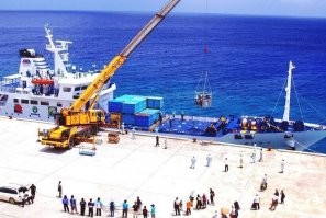 Судно стоит прямо у набережной. Хотите сказать,  трапик перекинуть невозможно?
... 
гораздо дешевле и проще, чем строительство и оборудование гавани.

А это что?