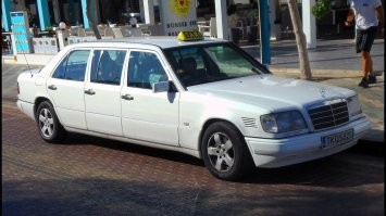 Это однозначно авто для трансферов из гостиниц или аэропортов.
На Кипре в 2016-2017 годах несколько раз ездили из Лимасола (основной морской порт) в Ларнаку (там аэропорт) на Мерседесе Е - класса в кузове W124 6 местном, как на фото ниже.  Потом они куда-то делись, видимо уже старые сильно для такси были и их заменили на миркоавтобусы Вито.