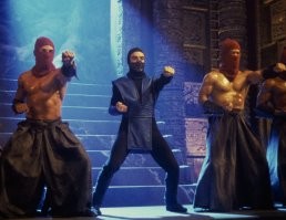 Успех был в динамических драках в разных декорациях, а так же очень угадали со саундтреком. К тому же костюмы были довольно простые но изящные, списанные с восточных стилей, вроде кимоно (или одеяния ниндзя), но без страз и бутафорских наворотов, как стало потом модно делать. Да и фильм вышел в эпоху повышенного спроса к фильмам про боевые искусства, и не тупо бокс - а про несколько разных стилей.
И да, команда постановщиков - сильно замарочилась к подбору даже персонажей второго плана, все они были в отличной физической форме и  это действительно создавало эффект того, что смотришь не обычный боевик, а действительно где-то в потустороннем мире - происходит турнир на который прибыли лучшие бойцы.
Всё это очень контрастирует на фоне второго Мортал Комбата, который был откровенной халтурой, и попыткой в тупую выехать на успехе первой части.