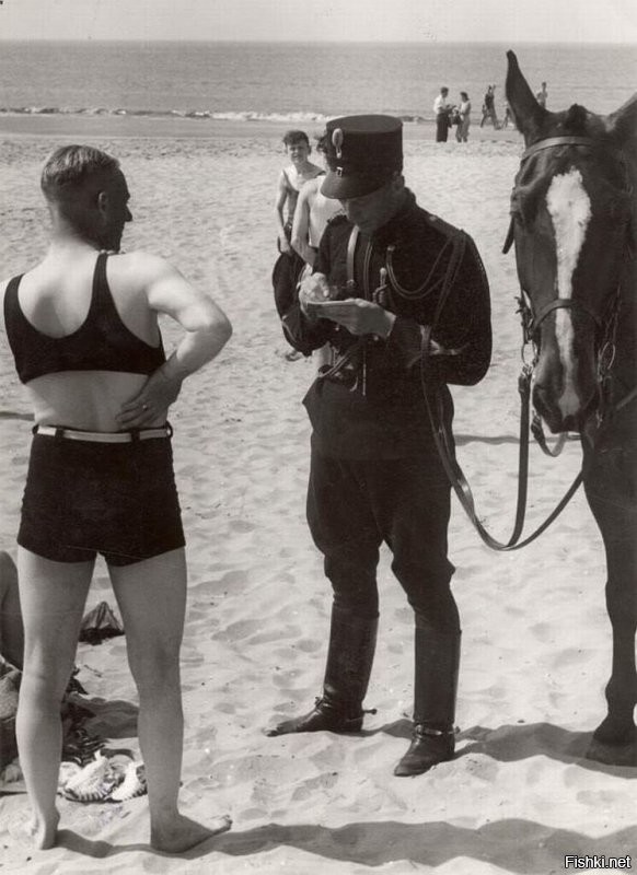 Выписывают штраф за смелый купальный костюм на пляже Хемскерка, Нидерланды 1931г