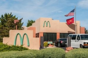 Единственный в мире McDonald’s с бирюзовым логотипом находится в городе Седона, штат Аризона.
Причина такого исключения достаточно забавна. Город Седона славится у туристов своим необычайным горным ландшафтом красных скал. Из-за этого в Седоне действуют правила, запрещающие зданиям особо выделяться на фоне окружающей природы. Когда в 1993 построили Макдональдс, городские власти сочли что ярко-желтая буква «M» будет конфликтовать с окружающими красными камнями, и выбрали более спокойный синий цвет.
Сам McDonald’s от этого только выиграл. Многие туристы останавливаются перекусить только ради его уникальности.